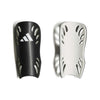 A pair of Adidas soccer shin guards shown side-by-side against a white background, one in textured black with a white Adidas logo, and the other in white with black trim.