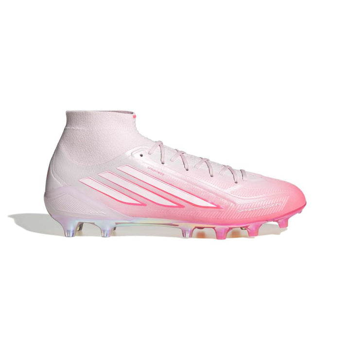 A single Adidas soccer cleat in a light pink and white gradient, featuring the signature three stripes on the side, set against a plain white background.