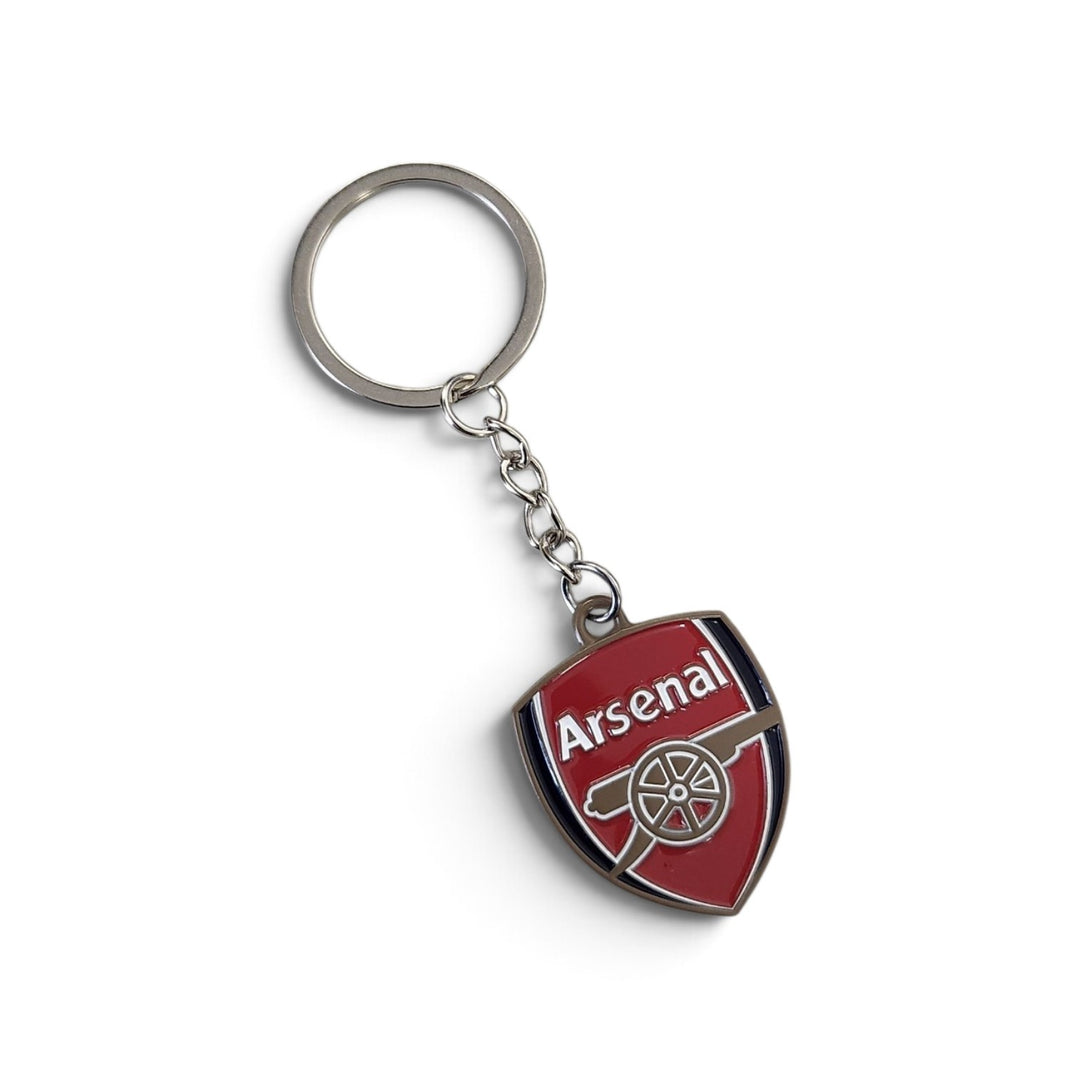 An Arsenal football club keychain featuring a red shield-shaped pendant with the club's cannon logo and 'Arsenal' text, attached to a silver metal key ring and chain, shown on a plain white background.
