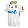 A white soccer jersey with gold trim on the collar and sleeve cuffs, featuring the ANZ logo in blue across the chest, the New Balance logo, and the Club Auckland crest. A red sleeve patch is visible on the right sleeve.