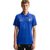 A young man modeling a blue Nike Chelsea FC polo shirt with yellow accents, paired with black shorts, against a plain white background.