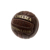 A dark brown leather soccer ball featuring gold lettering that reads 'CHELSEA' and 'FOOTBALL CLUB', isolated on a white background.
