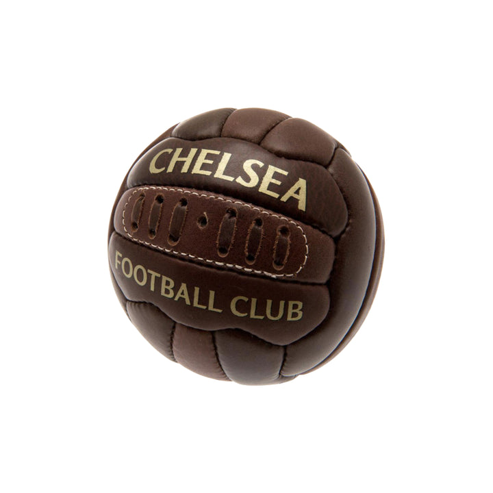 A dark brown leather soccer ball featuring gold lettering that reads 'CHELSEA' and 'FOOTBALL CLUB', isolated on a white background.