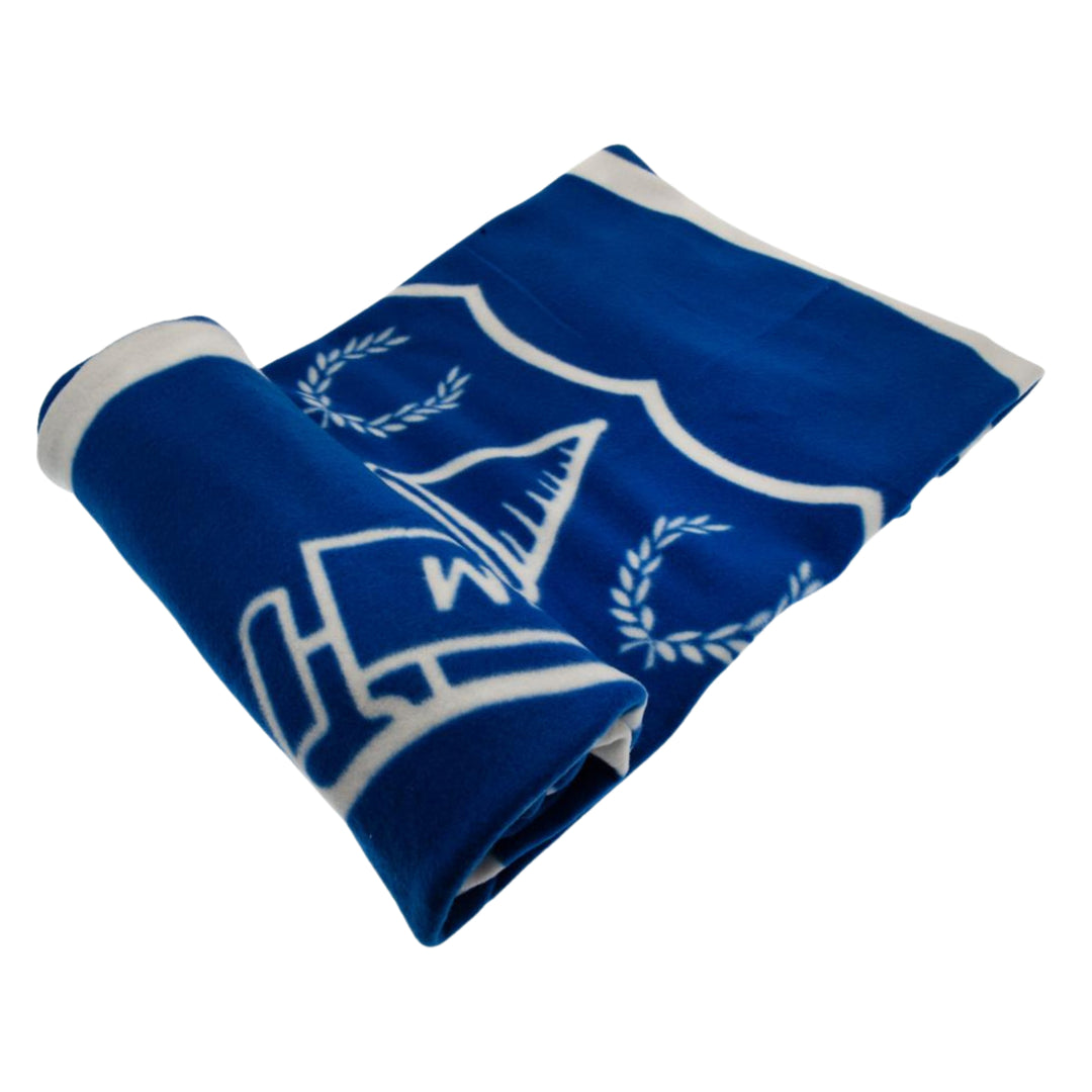 A blue and white fleece blanket featuring the University of Michigan Wolverines logo, shown rolled up on a plain white background.
