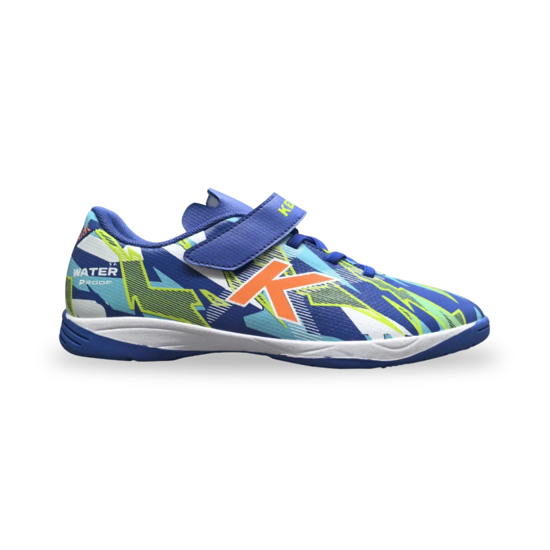 A kids' athletic shoe with a blue, green, and white geometric pattern, featuring a hook-and-loop strap closure and an orange 'K' logo on the side.