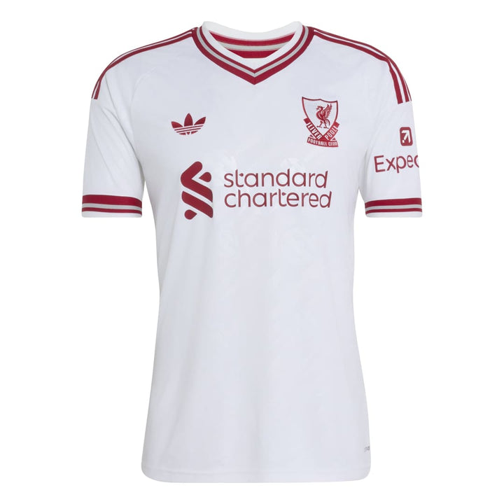 A white short-sleeve soccer jersey with red trim, featuring the Adidas logo, Liverpool FC crest, 'standard chartered' sponsor logo, and 'Expect' sleeve logo, shown on a plain white background.