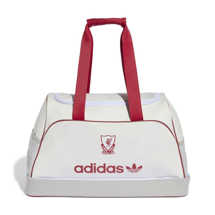 An Adidas duffel bag in off-white with red handles, red piping, and red branding on the front, set against a plain white background.