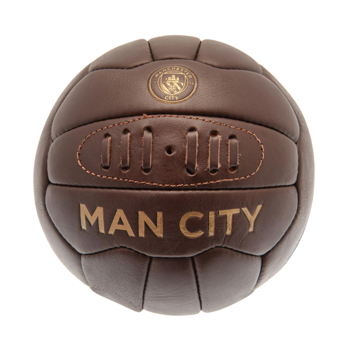 Brown leather ball with 'Man City' text on a white background
