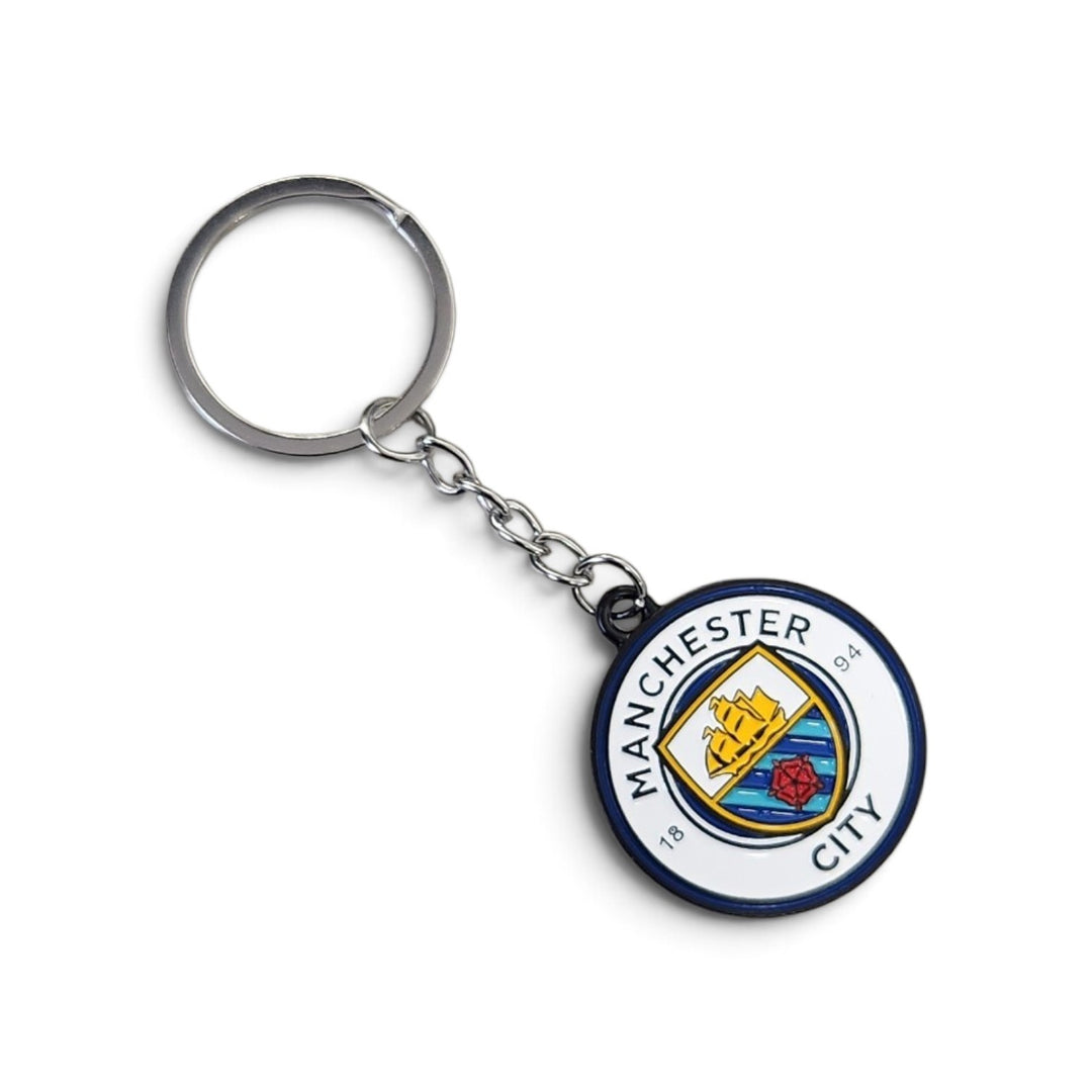 A Manchester City FC keychain featuring a circular metal charm with the club's crest, attached to a silver split key ring on a clean white background.