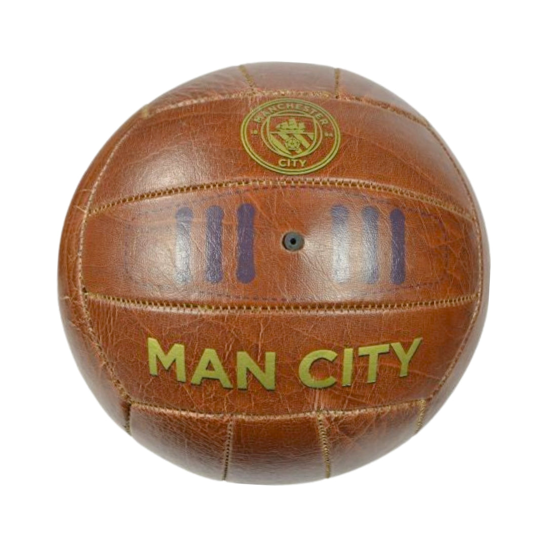 Vintage-style brown leather soccer ball with 'Man City' text and logo on a white background