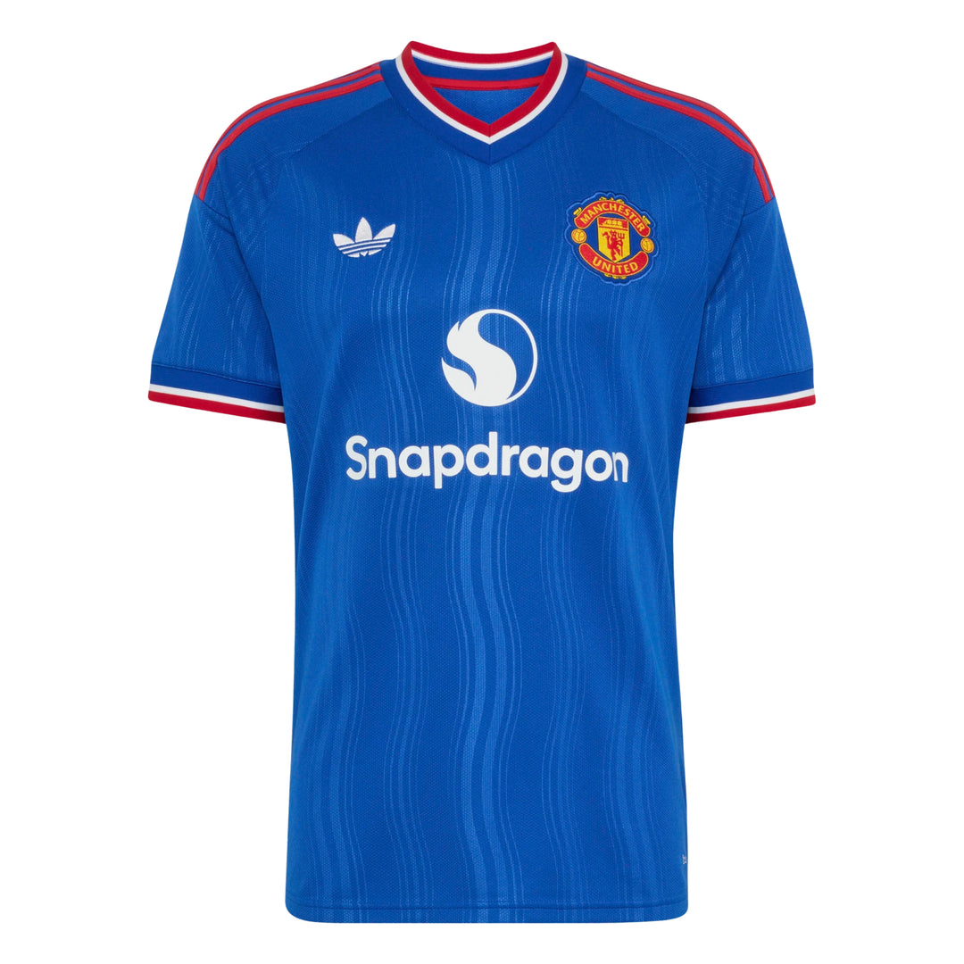 A blue short-sleeve soccer jersey with red and white trim on the collar and cuffs, featuring the Adidas logo on the right chest, the Manchester United crest on the left chest, and the Snapdragon sponsor logo across the center.
