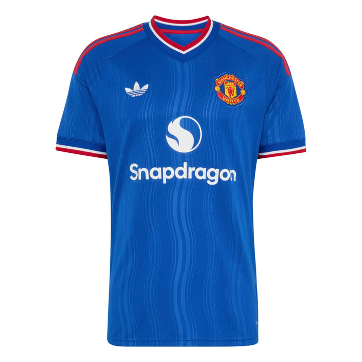 A blue short-sleeve soccer jersey with red and white trim on the collar and cuffs, featuring the Adidas logo on the right chest, the Manchester United crest on the left chest, and the Snapdragon sponsor logo across the center.