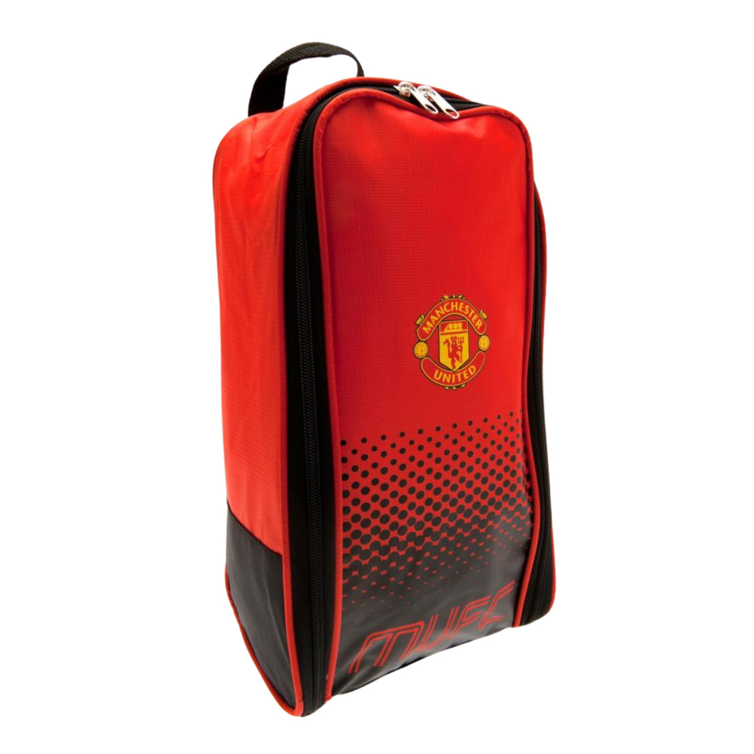A red and black Manchester United boot bag with the club's crest on the front, a top carry handle, and a gradient dot pattern on the lower front panel.