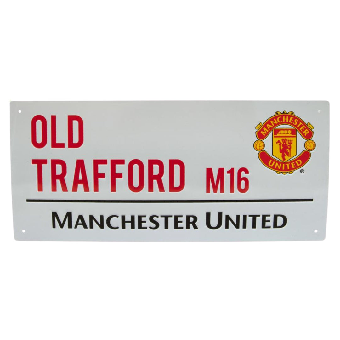 A rectangular white metal sign featuring red and black text that reads 'OLD TRAFFORD M16 MANCHESTER UNITED' alongside the Manchester United crest, shown against a plain white background.
