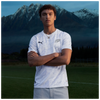 Person wearing NZ All Whites shirt with NZ mountains in background