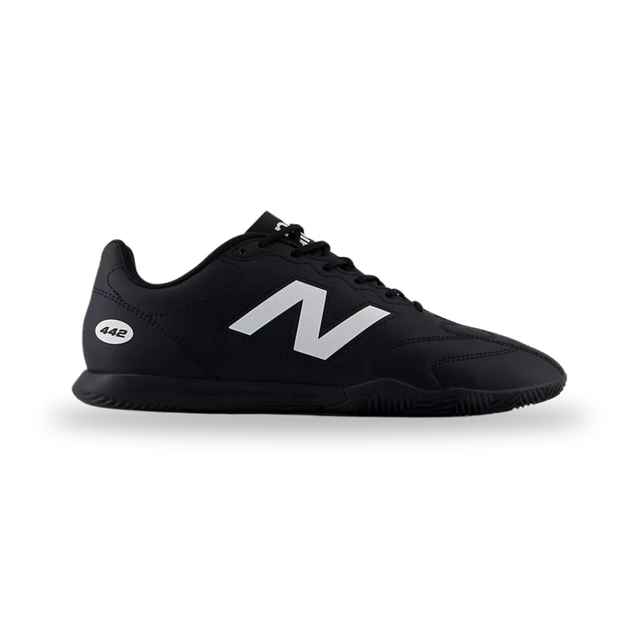 Black Adidas sneaker with white stripes on a light gray background