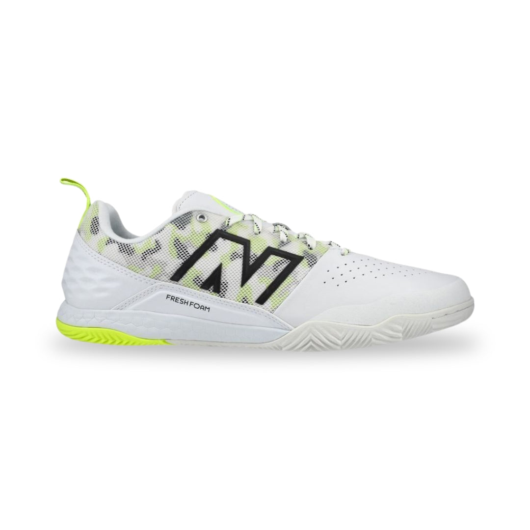 White athletic shoe with black logo and green accents on a white background
