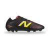 A New Balance soccer cleat in black with a prominent yellow 'N' logo, red textured pattern details, and silver metal studs, shown from a side profile on a white background.