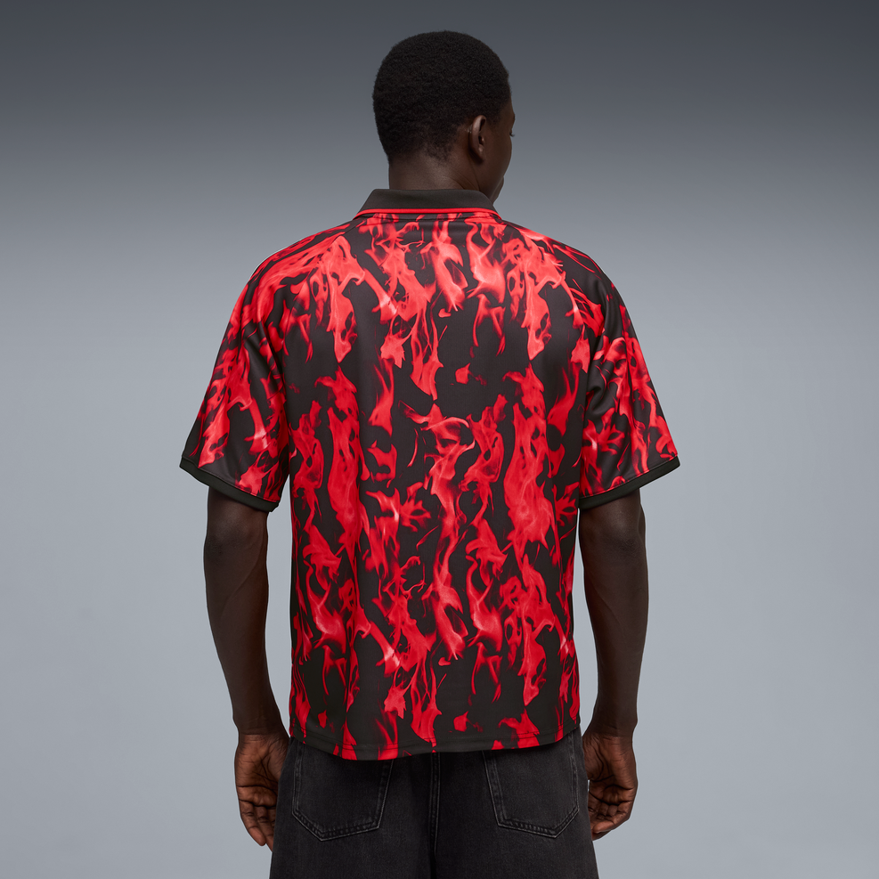 Person wearing a red and black patterned shirt on a gray background