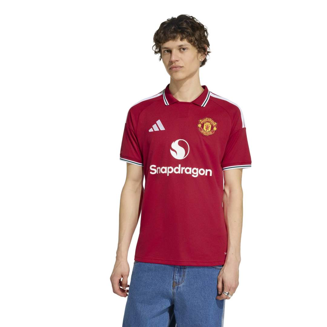 Person facing forward wearing Manchester United Home Jersey and jeans