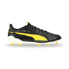 A Puma soccer cleat in black leather with a vibrant yellow gradient stripe, yellow studs, and a white sole, shown from the side on a white background.