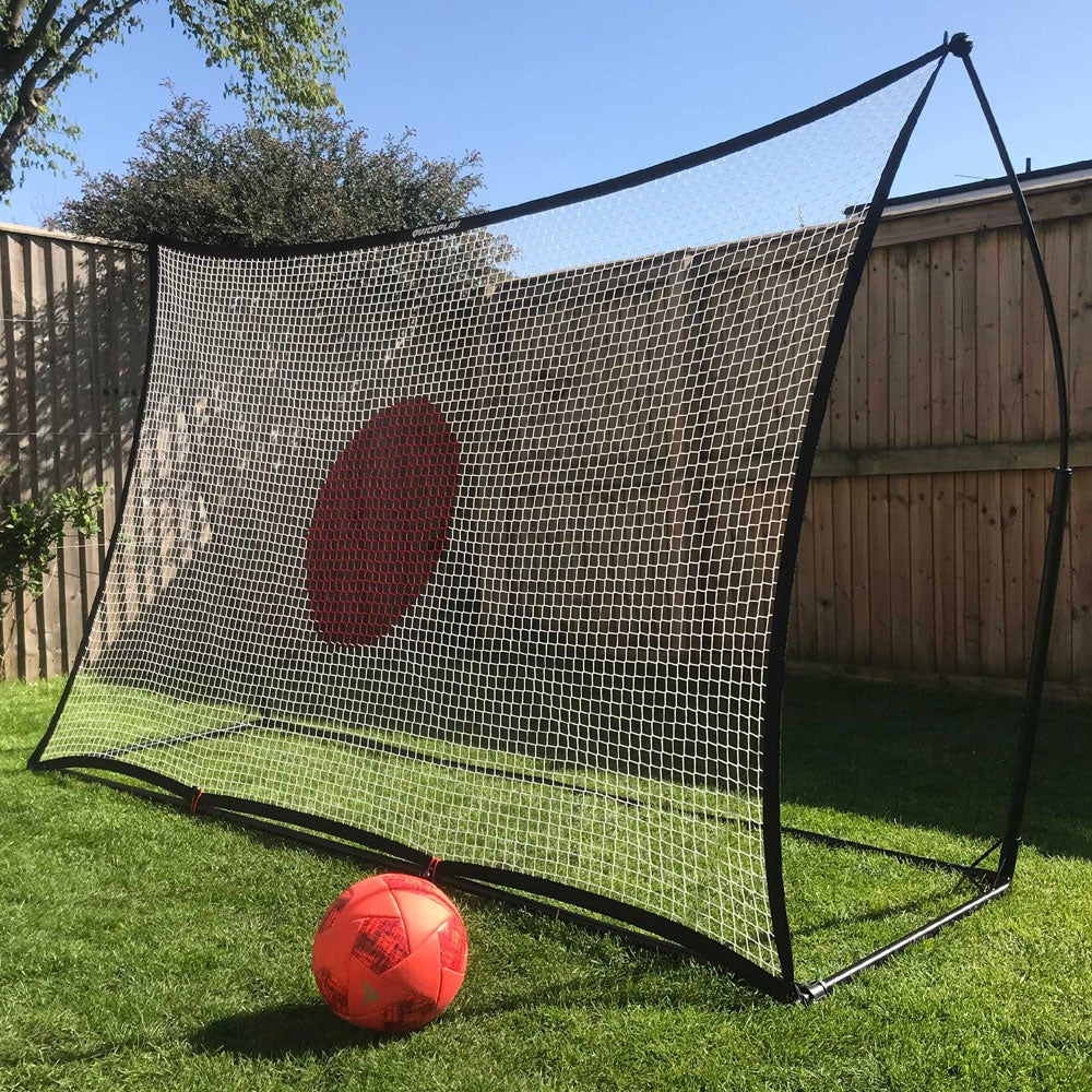 Soccer practice net with a red ball on a grassy area