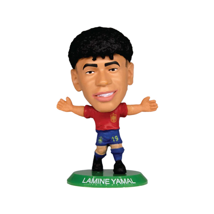 A Lamine Yamal soccer figurine with arms outstretched, wearing a red Spain jersey and blue shorts, standing on a green base labeled 'LAMINE YAMAL'.