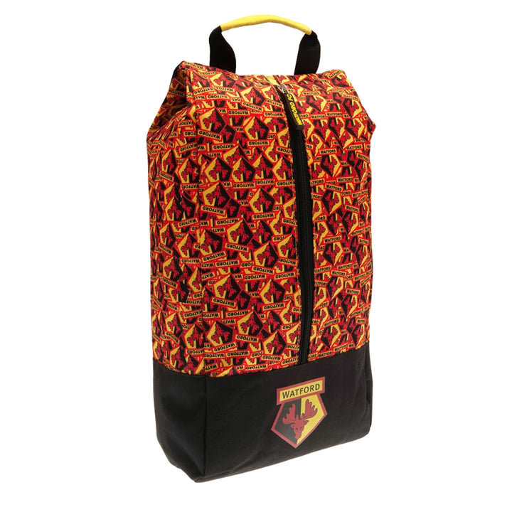 A tall zippered bag with a red, orange, and yellow patterned upper section and a solid black lower section, featuring a yellow top handle and a Watford club crest patch on the front.